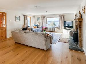 a living room with a couch and a television at Rubha Lodge in Shieldaig