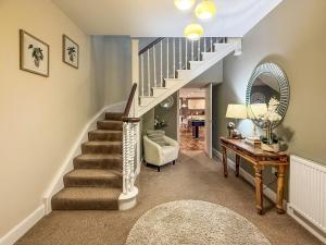 a living room with a staircase and a table at Darris Farmhouse in Lochend
