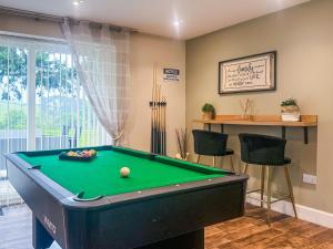 a room with a pool table and two chairs at Darris Farmhouse in Lochend