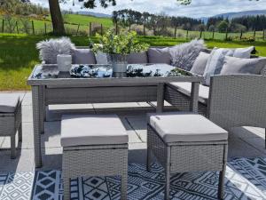 a table and chairs on a patio with a table and chairs at Darris Farmhouse in Lochend