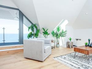 a living room with a white couch and potted plants at The Penthouse in Woolacombe