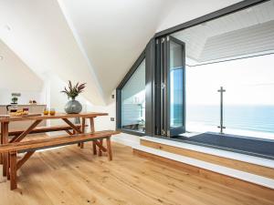 a dining room with a table and a large window at The Penthouse in Woolacombe