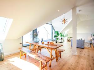 a living room with a wooden table and benches at The Penthouse in Woolacombe +18 photos