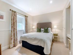 a bedroom with a large bed with green pillows at Coach House - Uk49887 in Preston +24 photos