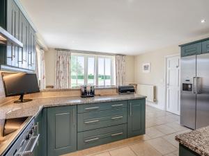 a kitchen with green cabinets and a refrigerator at Coach House - Uk49887 in Preston