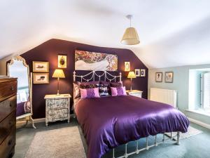a bedroom with a purple bed with two night stands at Pilgrim Corner in Minehead +25 photos