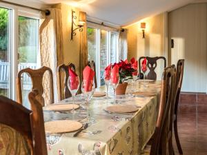a table with red flowers and wine glasses on it at Pilgrim Corner in Minehead