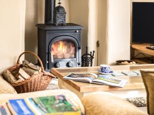 a living room with a fireplace and a table with a book at Pilgrim Corner in Minehead