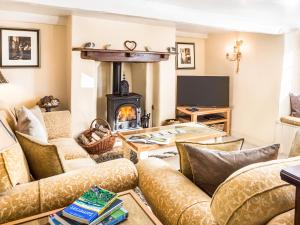 a living room with couches and a wood stove at Pilgrim Corner in Minehead