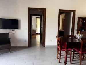a dining room with a table and chairs and a television at Bea Villa Bea in Caldarola