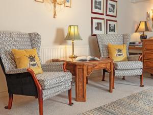 a living room with two chairs and a table at Pilgrim Corner in Minehead