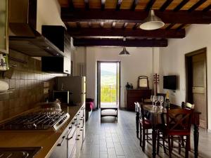 a kitchen with a stove and a table and a dining room at Bea Villa Bea in Caldarola