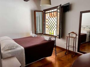 a bedroom with a bed and a window and a mirror at Bea Villa Bea in Caldarola +64 photos