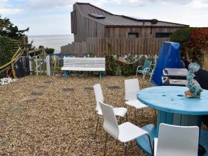 a patio with a table and chairs and a bench at Fronks House in Harwich