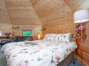 a bedroom with a bed in a wooden cabin at Coot Roundhouse - Uk33890 in Cullompton