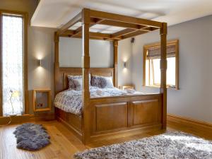 a bedroom with a wooden canopy bed with a rug at Carr End Barn A in Preesall +6 photos