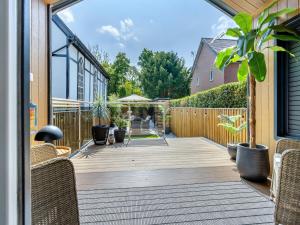 a patio with wicker chairs and a wooden deck at Aqueduct Hideaway in Llangollen