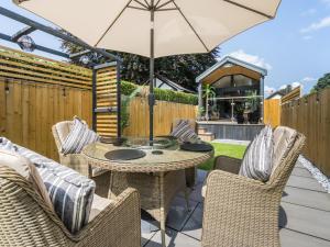 a patio with a table and chairs and an umbrella at Aqueduct Hideaway in Llangollen +15 photos