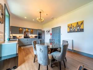 a kitchen and dining room with a table and chairs at Mossknowe Escape in Annan