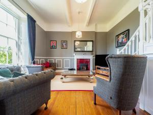 a living room with two chairs and a fireplace at Mossknowe Escape in Annan