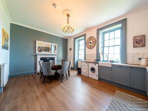 a kitchen and dining room with a table and chairs at Mossknowe Escape in Annan