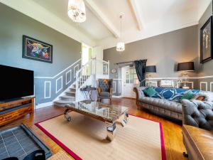a living room with a couch and a tv at Mossknowe Escape in Annan