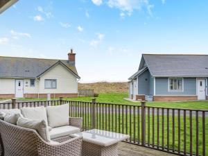 a patio with a chair and a table on a fence at Stargazer in Beadnell