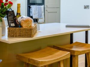 a kitchen counter with a basket of groceries and two stools at Rinstone Lodge in Thornton Dale