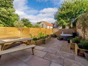a garden with a wooden fence and a wooden picnic table at Rinstone Lodge in Thornton Dale