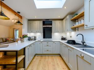a kitchen with white cabinets and a sink at Rinstone Lodge in Thornton Dale