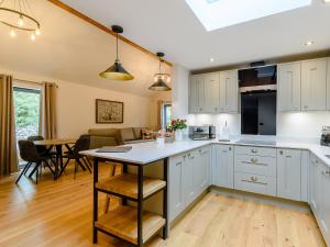 a kitchen with white cabinets and a dining room at Rinstone Lodge in Thornton Dale +13 photos