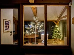 a room with a christmas tree and a table with lights at Windover Barn in Horsham