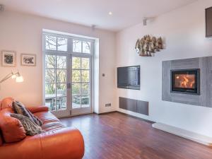 a living room with a couch and a fireplace at Orrest Howe in Windermere