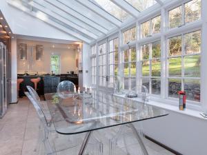 a dining room with a glass table and windows at Orrest Howe in Windermere +14 photos