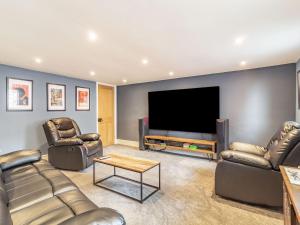 a living room with two couches and a flat screen tv at Riversdelle in Beccles