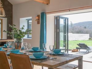 a dining room with a wooden table with blue dishes on it at The Pendre Longbarn in Pentre-briwnant
