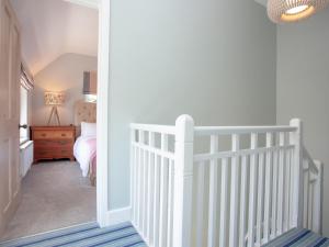 a white crib in a room with a bedroom at The Pink House in Branscombe