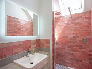 a bathroom with a sink and a red brick wall at The Pink House in Branscombe +38 photos