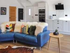 a blue couch with pillows in a living room at Ty Twm in Criccieth
