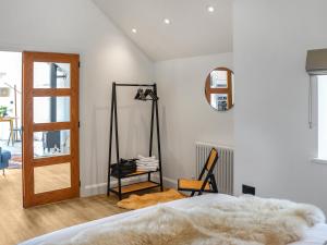 a bedroom with a bed and a mirror at Ty Twm in Criccieth +4 photos