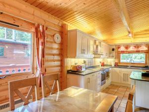 a kitchen with wooden walls and a wooden ceiling at Cherry Lodge- Uk37608 in Legbourne
