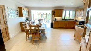a kitchen and dining room with a table and chairs at Llwyn Ysgaw in Cemaes Bay