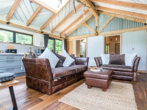 a living room with two leather couches and a table at Meadow Hide - Uk36773 in Chichester