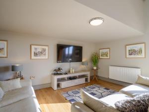 a living room with two couches and a flat screen tv at Penthwaite in Leyburn