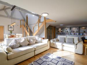 a living room with two white couches and a staircase at Penthwaite in Leyburn