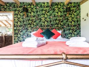 a bedroom with a bed with red and green wallpaper at Meadow Hide - Uk36773 in Chichester