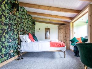 a bedroom with a bed with colorful pillows at Meadow Hide - Uk36773 in Chichester +19 photos