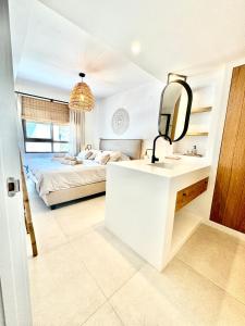 a bedroom with a bed and a sink and a mirror at Penthouse Seven Oceans Moraira in Moraira