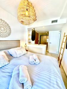 a bedroom with a large bed with towels on it at Penthouse Seven Oceans Moraira in Moraira