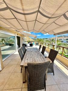 a wooden table and chairs on a patio with an umbrella at Penthouse Seven Oceans Moraira in Moraira +31 photos